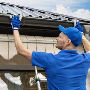 man installing house roof rain gutter system